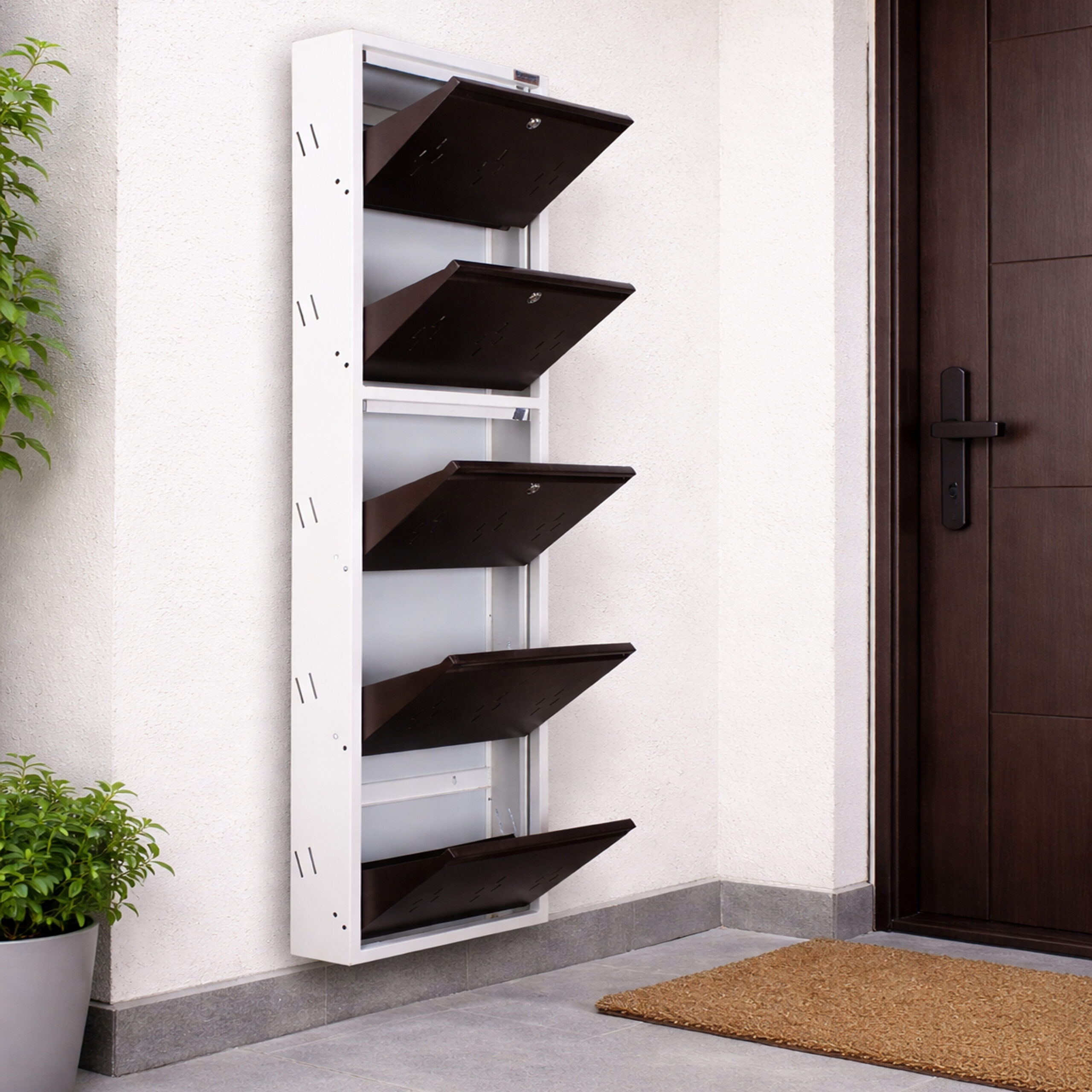 Wall-mounted 4-door grey metal shoe rack with white frame installed near wooden entrance door – space-saving premium Jootarack shoe storage cabinet